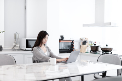 一个年轻的女人在家里使用电脑