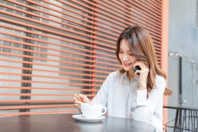 中国女白领在室外喝咖啡打电话