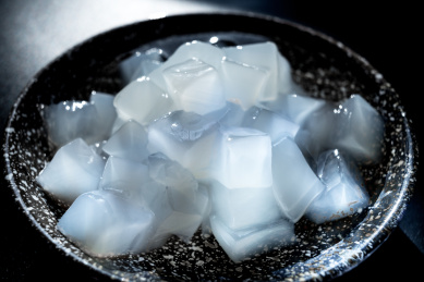 摆放在黑色桌面上陶瓷碗中的白色椰子肉，