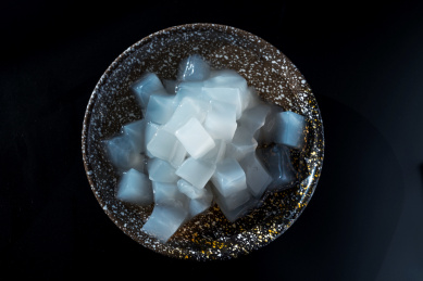 摆放在黑色桌面上陶瓷碗中的白色椰子肉，