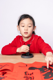 在木质书案上研墨的中国女孩