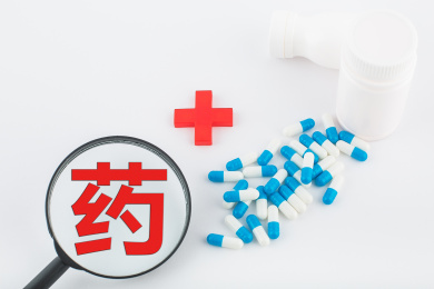 白色背景纸上放着蓝白色胶囊和白色药瓶。