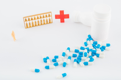 白色背景纸上放着蓝白色胶囊和白色药瓶。