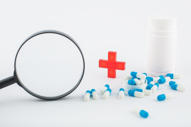 白色背景纸上放着蓝白色胶囊和白色药瓶。