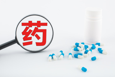 白色背景纸上放着蓝白色胶囊和白色药瓶。