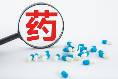 白色背景纸上放着蓝白色胶囊和白色药瓶。