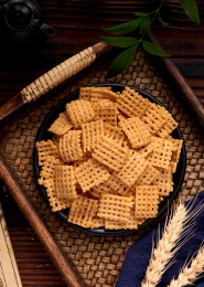 木纹背景上餐具里堆放的锅巴