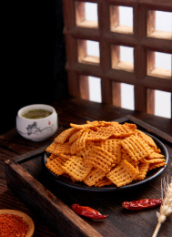 木纹背景上餐具里摆放的香辣锅巴