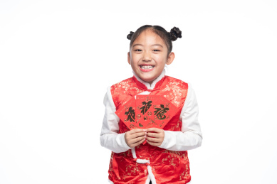 一位小女孩儿手拿着红包面向镜头微笑