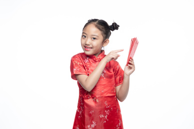 一位小女孩儿手拿着红包面向镜头微笑