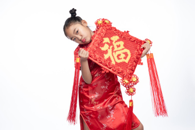 一位小女孩儿手拿着福字面向镜头微笑