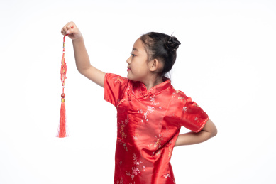 一位小女孩儿手拿着福字面向镜头微笑