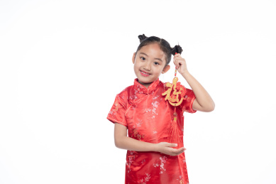 一位小女孩儿手拿着福字面向镜头微笑