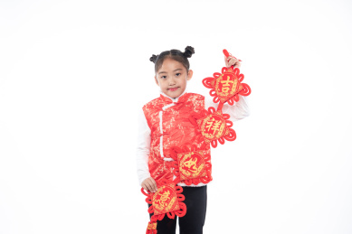 一位小女孩儿手拿着对联面向镜头微笑