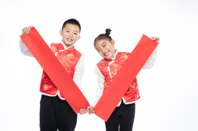 一男一女两个小孩儿拿着对联面向镜头微笑