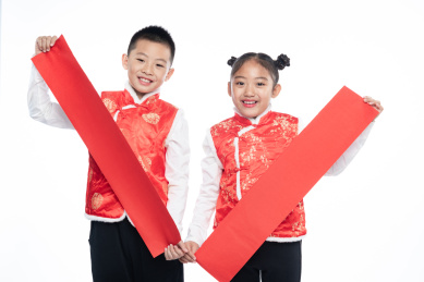 一男一女两个小孩儿拿着对联面向镜头微笑