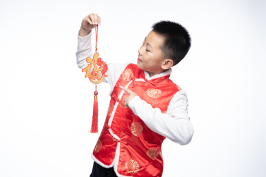 一位男孩儿拿着福字看向镜头