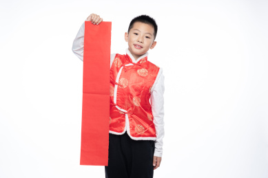 一位男孩儿拿着对联看向镜头