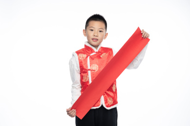 一位男孩儿拿着对联看向镜头