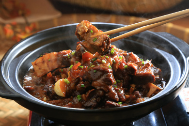 黑色砂锅里冒着热气的干锅焖全牛