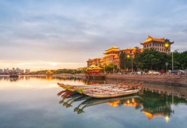 中国福建省厦门市集美学村龙舟池里的龙舟及岸边南侨楼群建筑夜景