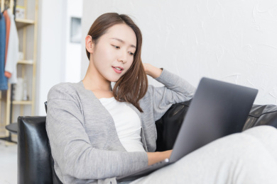 一名年轻女性坐在沙发上使用电脑