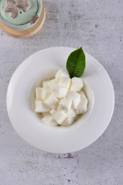 一份白色奶酪方砖放在白色底板上