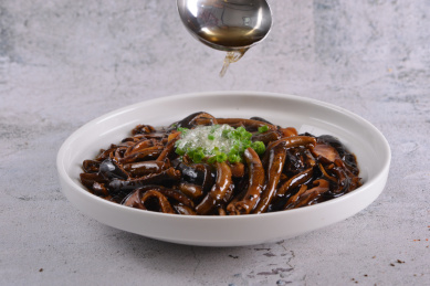 一盘热油鳝丝泥鳅鱼放在白色石板上