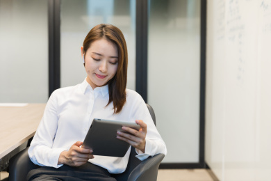 一位职场女性低头看平板正在工作