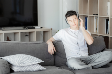 在沙发上听音乐的年轻人