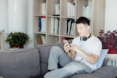 在沙发上听音乐的年轻人