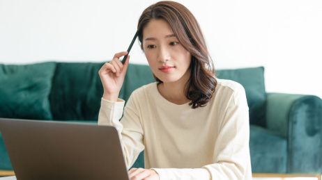 一名年轻女性在家里的客厅坐在地毯上办公