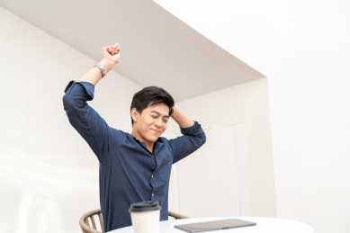 一名年轻的商务男士坐在椅子上伸懒腰