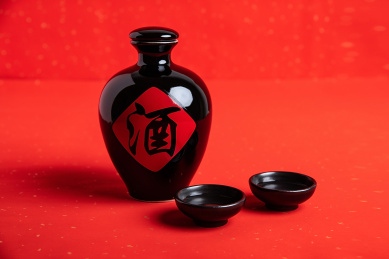 红色背景上一壶中国传统酿造的白酒