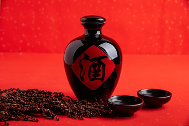 红色背景上一壶中国高粱酒和高粱穗 
