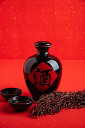 红色背景上一壶中国高粱酒和高粱穗  