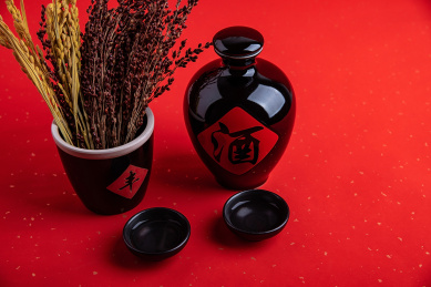 红色背景上一壶白酒和高粱穗稻穗