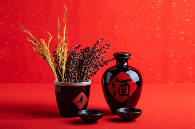 红色背景上一壶白酒和高粱穗稻穗