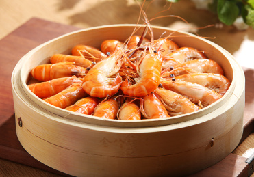木板上蒸屉里的清蒸罗氏虾
