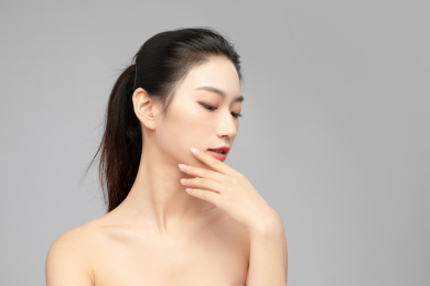 灰色背景里的亚洲美女面部特写，化妆护肤整容