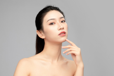 灰色背景里的亚洲美女面部特写，化妆护肤整容