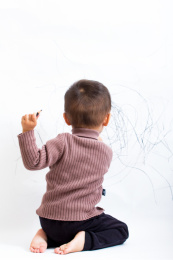 天真可爱的孩童在白墙上涂鸦