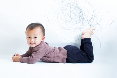 天真可爱的孩童在白墙上涂鸦