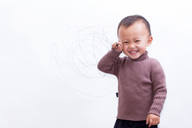 天真可爱的孩童在白墙上涂鸦