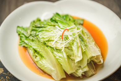 暗色木纹桌面上放着一份白灼罗马生菜