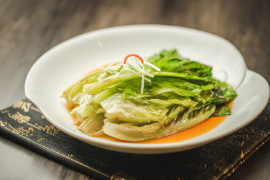 暗色木纹桌面上放着一份白灼罗马生菜