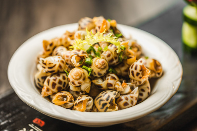 暗色木纹桌面上放着一份巧手浸花螺