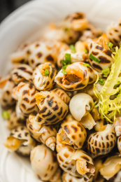 暗色木纹桌面上放着一份巧手浸花螺