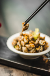 暗色木纹桌面上放着一份巧手浸花螺