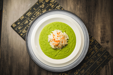 暗色木纹桌面上放着一份甜豆泥滑鸡片